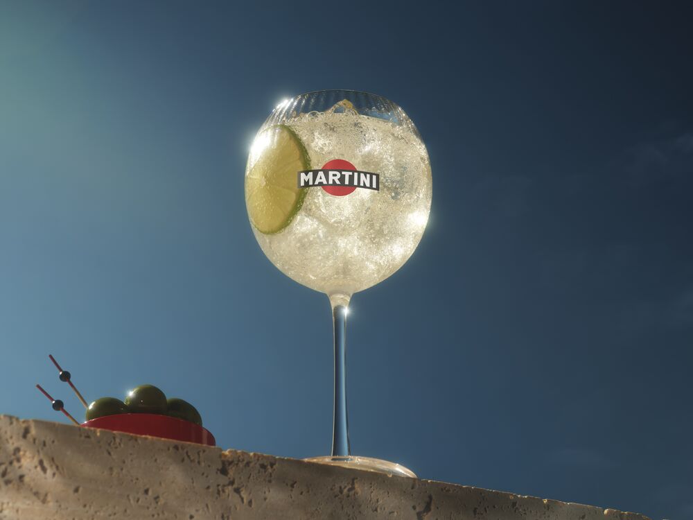 A close-up shot of Vermouth Bianco being poured into a glass, showcasing its clear hue and clarity. 